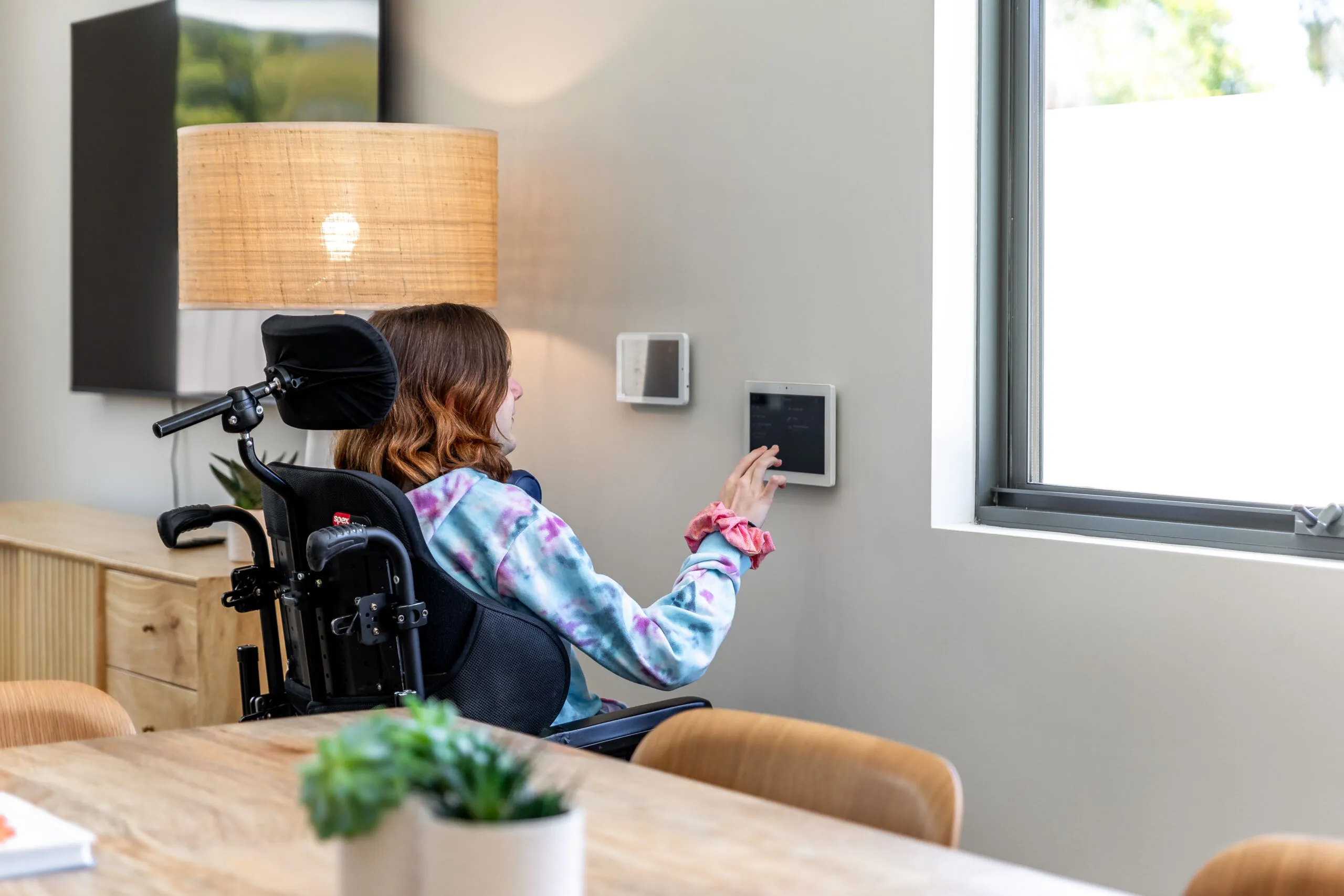 A tenant in a wheelchair using a smart panel