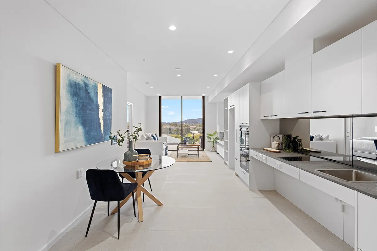 The inside of an apartment with kitchen and dining table