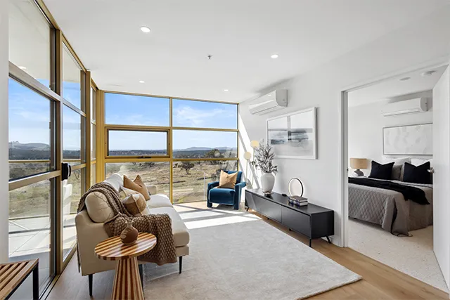 A loungeroom with large windows looking out to parkland