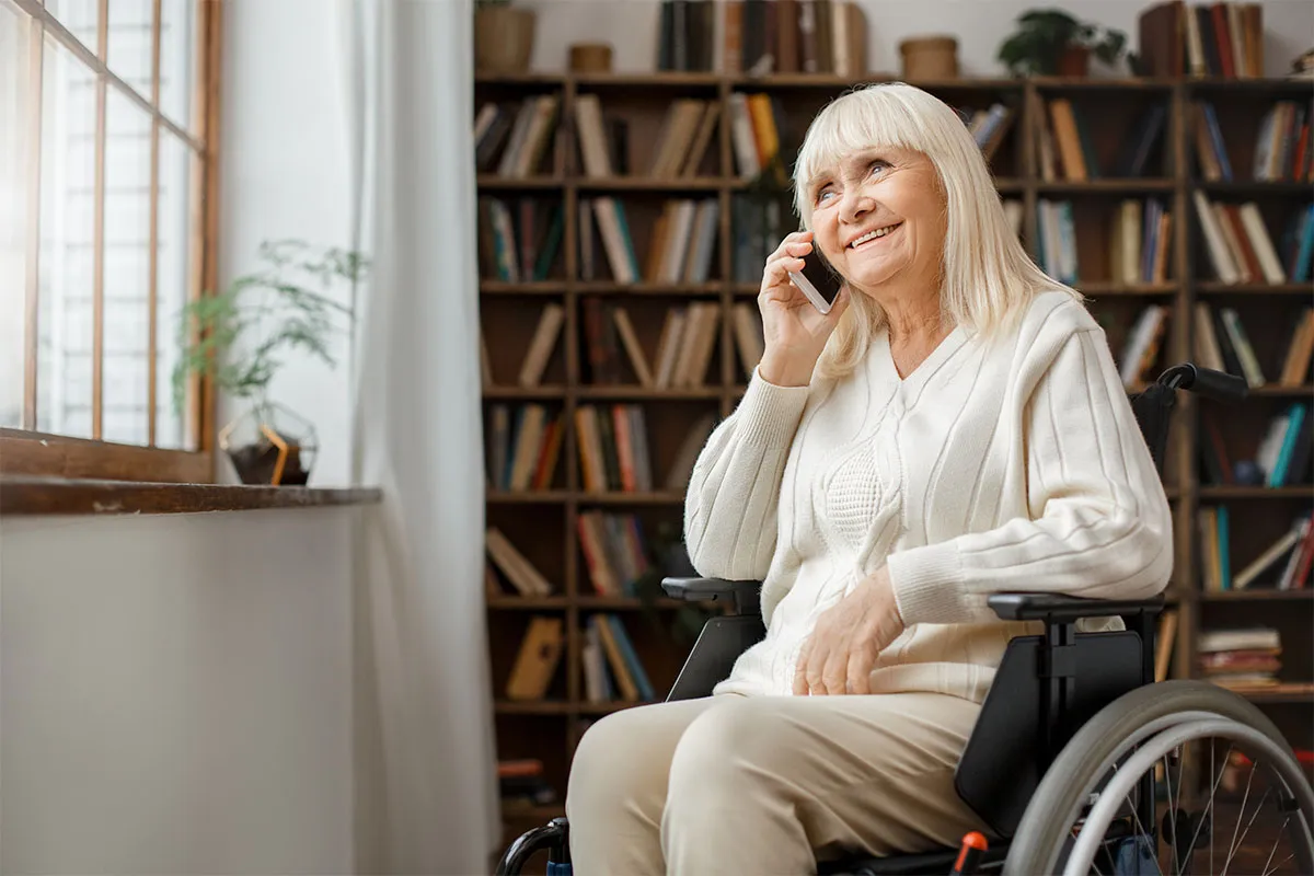 A woman in a wheelchair speaking on a phone