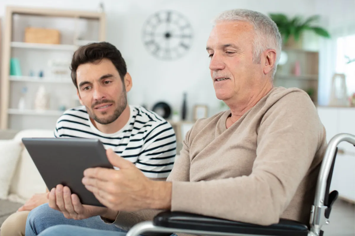 A man in a wheelchair using a tablet