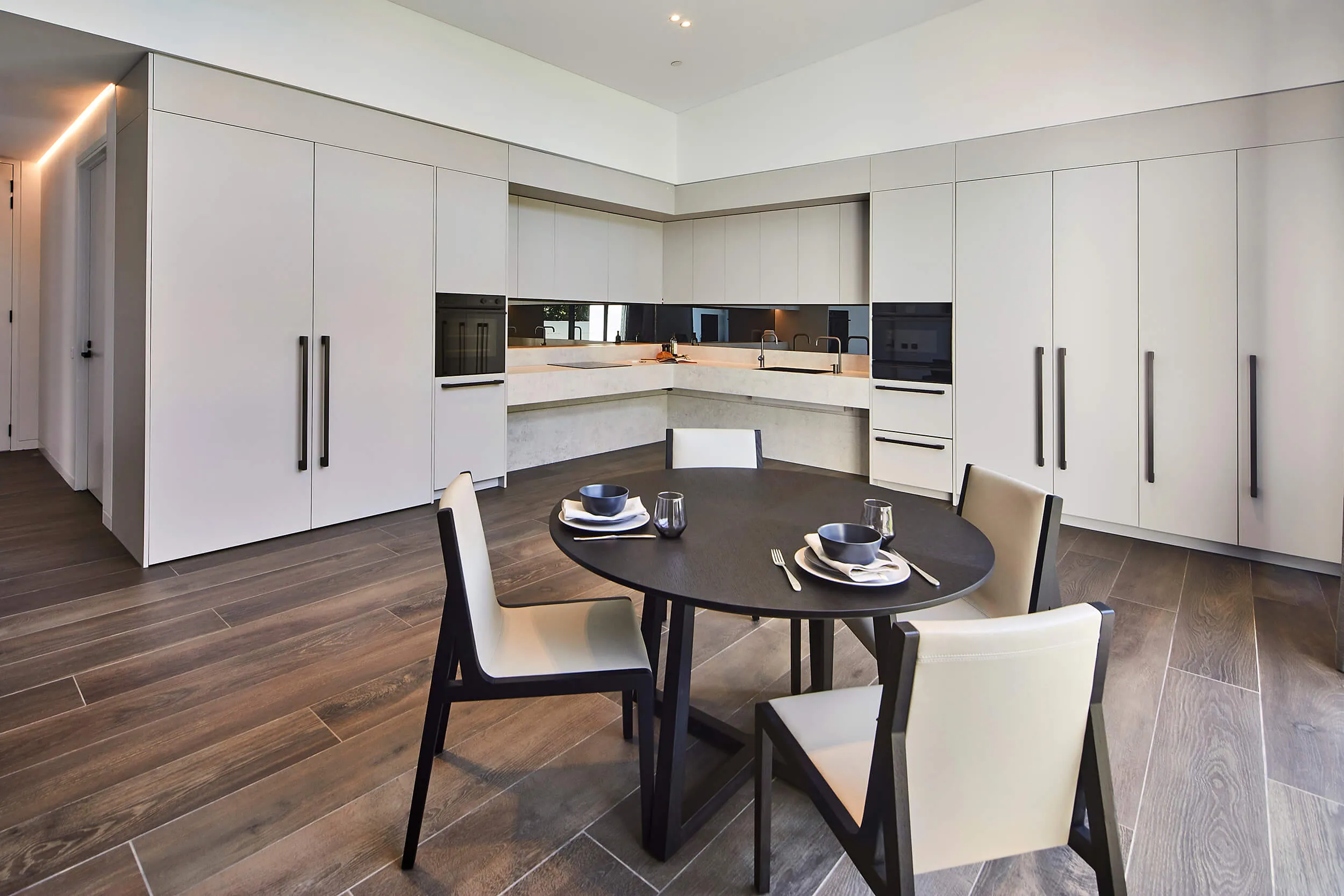 A kitchen with a dining table and wood floors